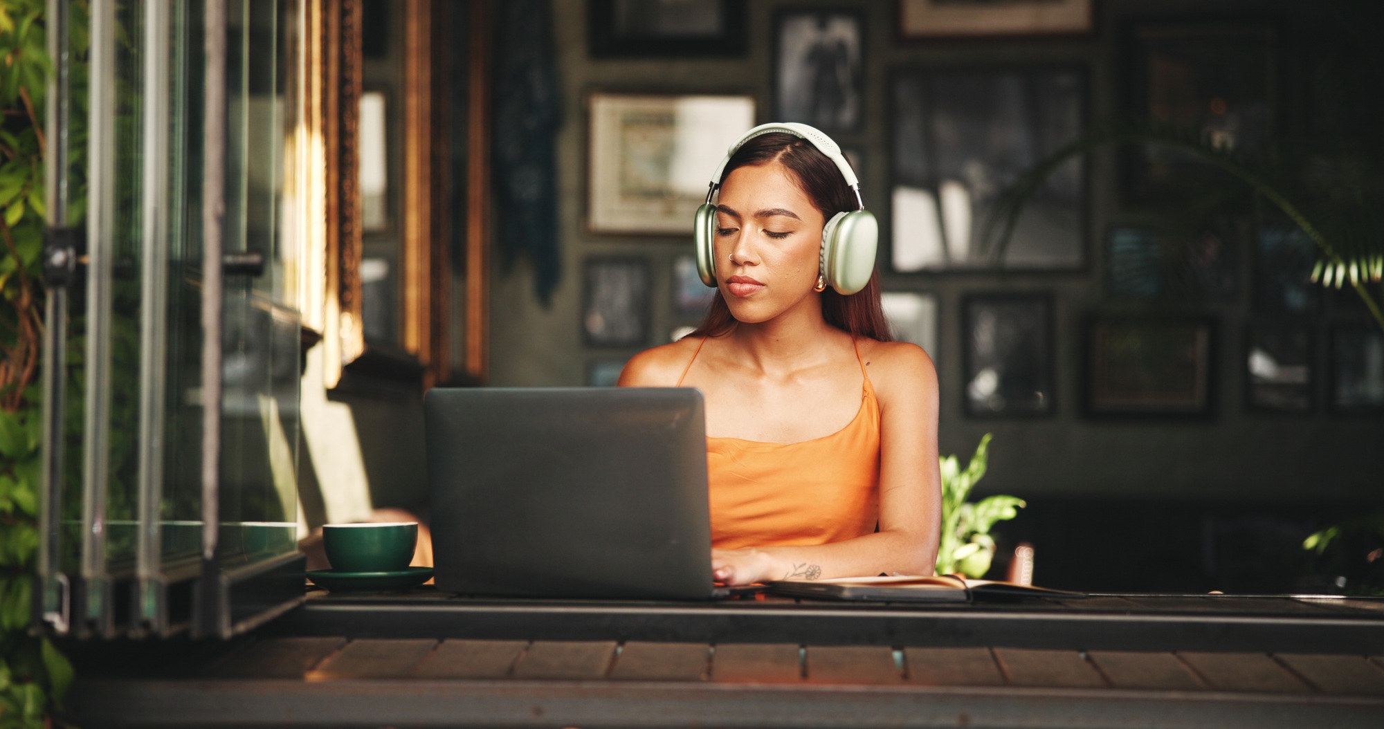 Student, headphones and laptop with woman in cafe on campus for college research, education or lear